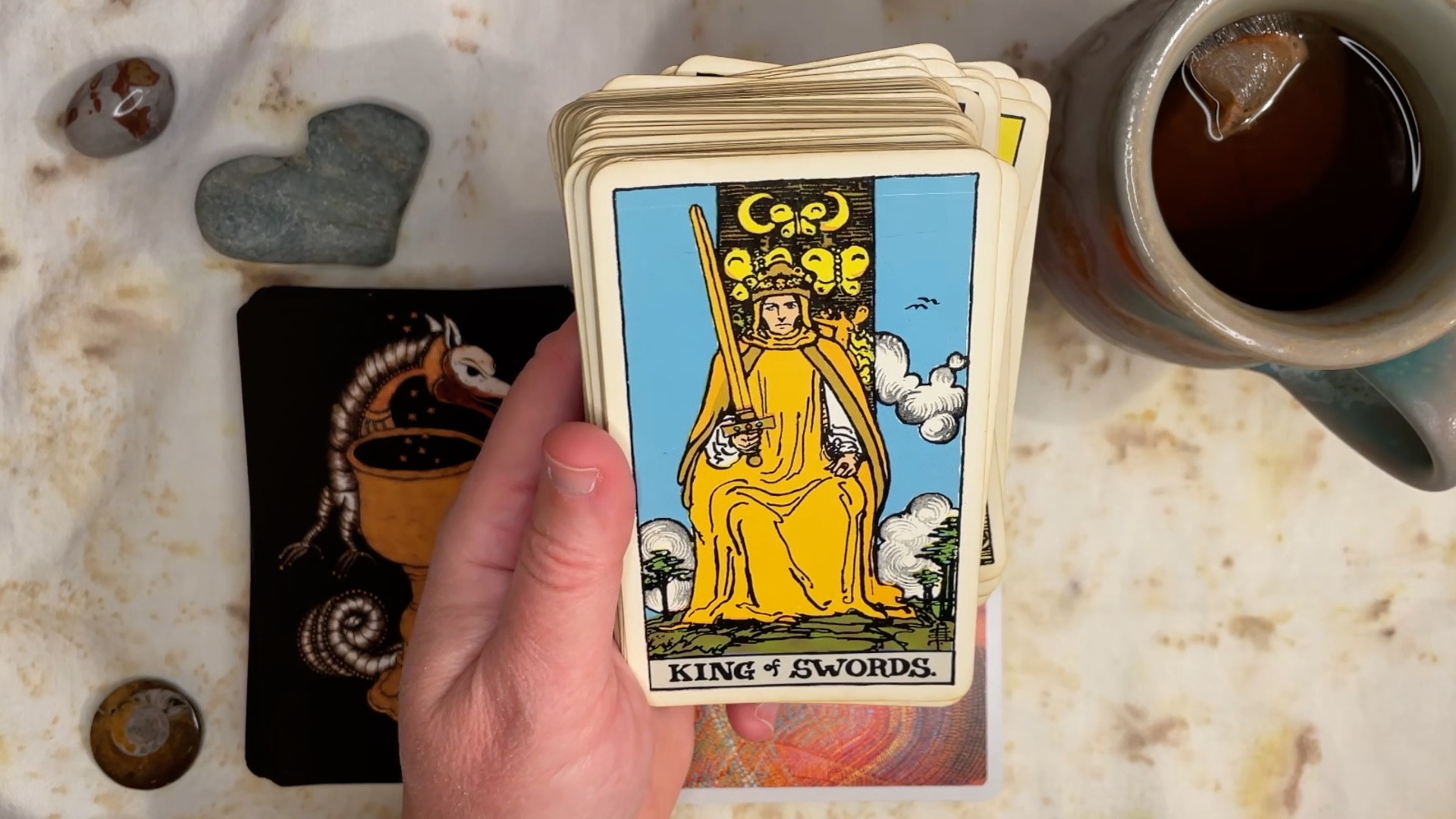 The King of Swords card from the Albano Waite tarot deck, showing a cartoon drawing of a man in yellow sitting on a throne.