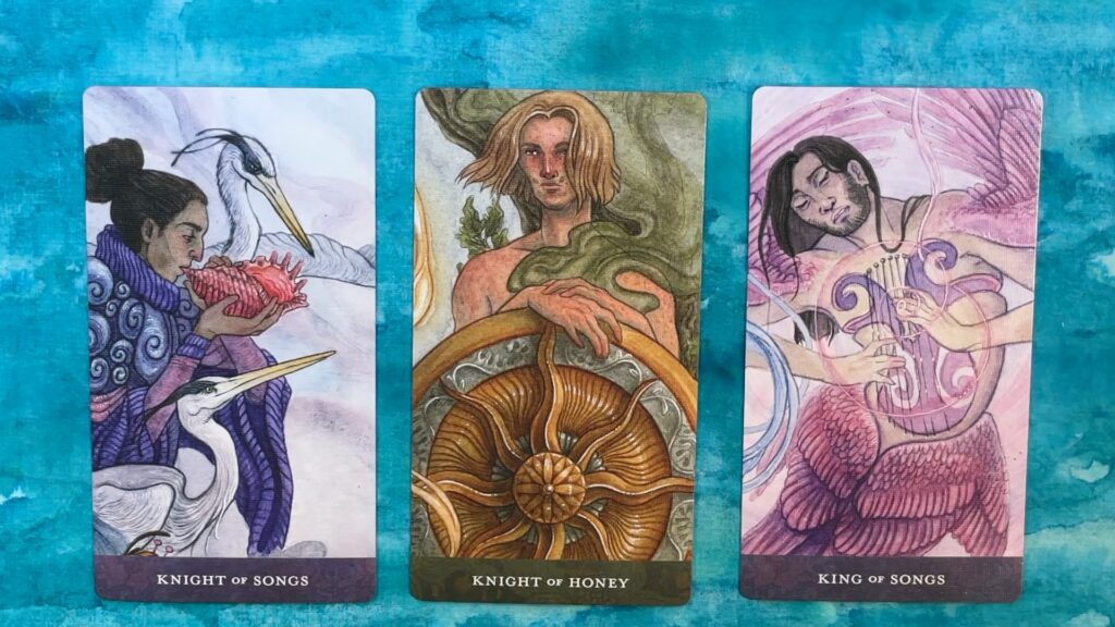 Three cards from the Blood Moon Tarot, depicting fantastical humans with a variety of physical characteristics and gender expressions.